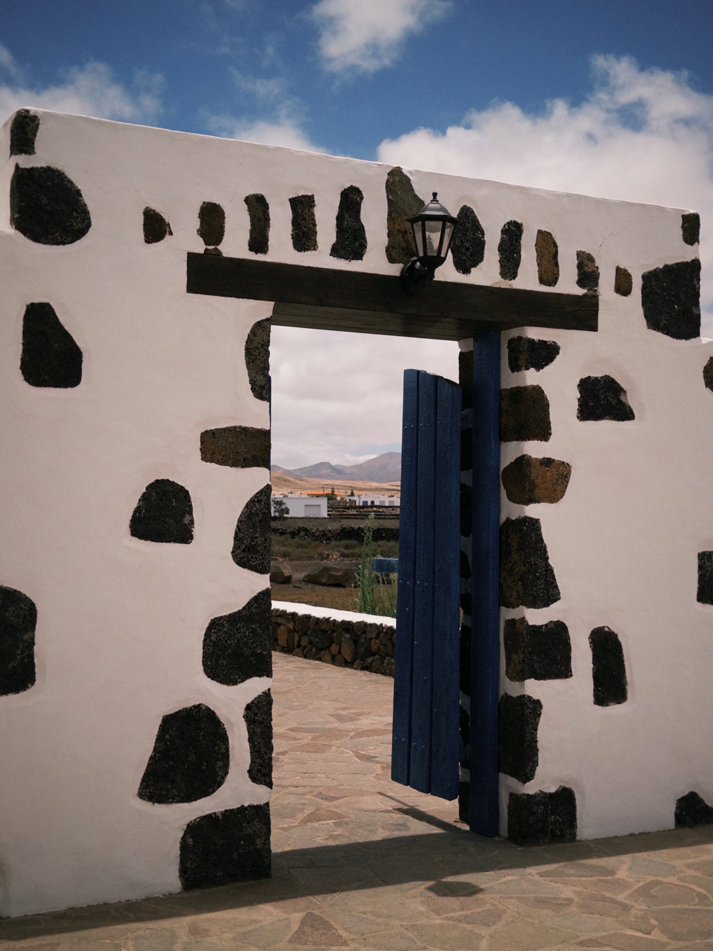Entrada de piedra volcánica con puerta azul